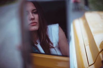 a woman sitting in the back of a yellow car