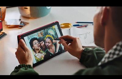 a man sitting at a table drawing on a tablet