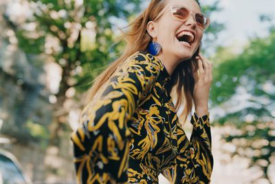 a woman in a black and yellow dress laughing