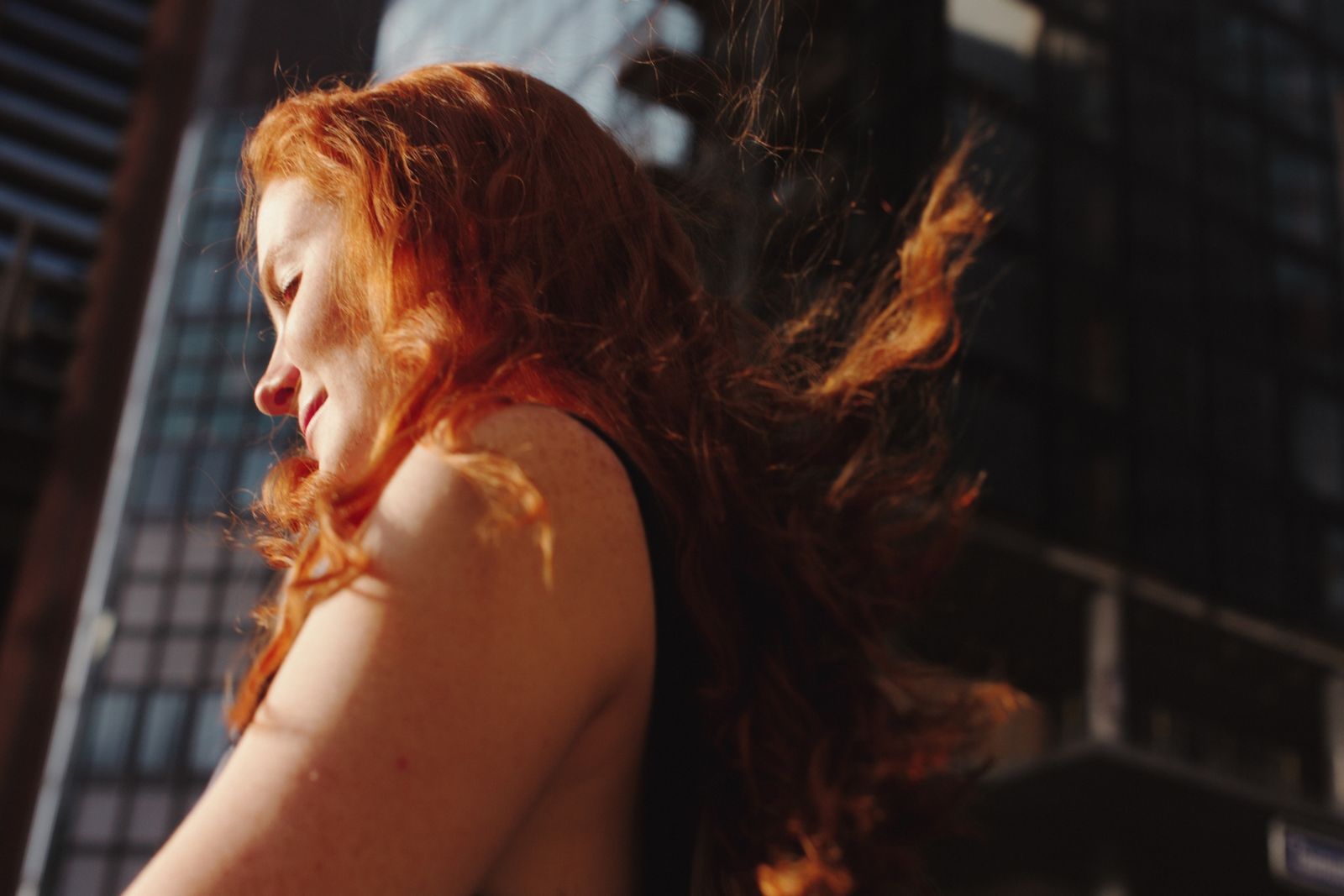 a woman with red hair walking down a street