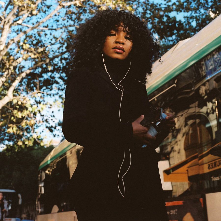 a woman standing on a street holding a camera