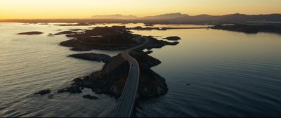 an aerial view of a road going over a body of water