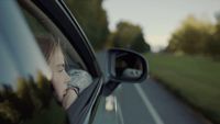 a woman looking out the window of a car