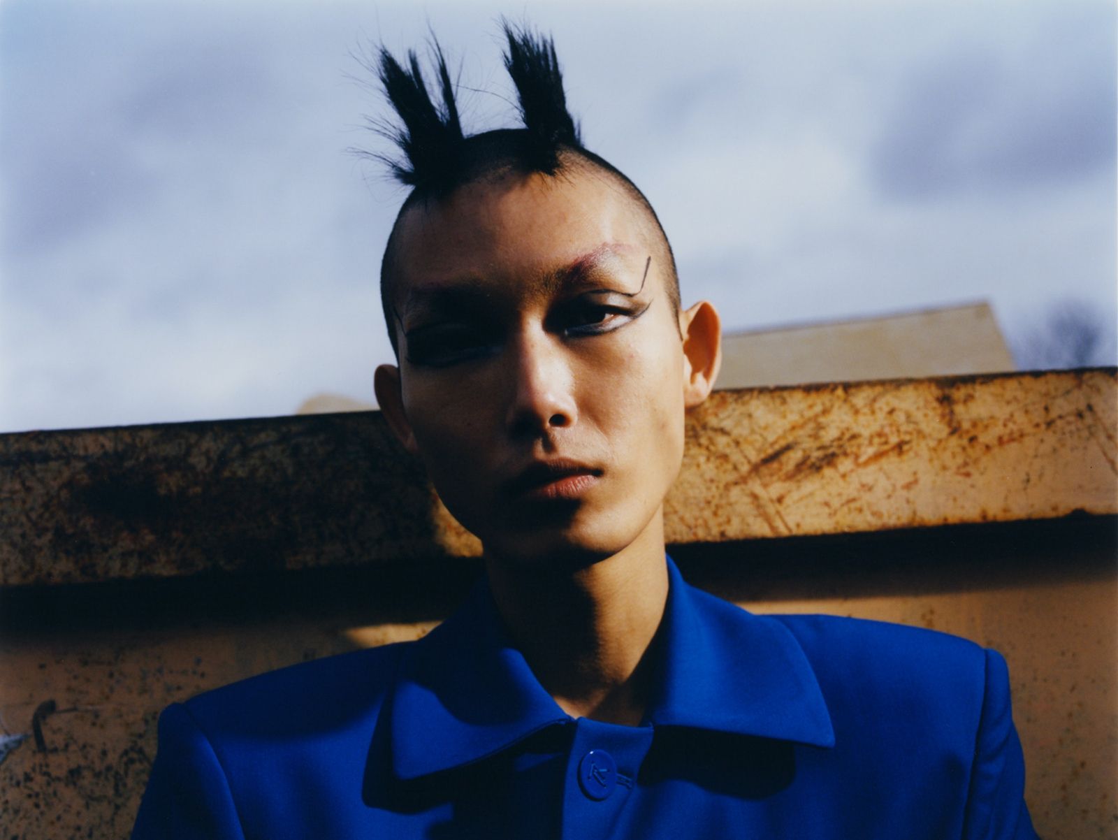 a man with a shaved head and blue shirt