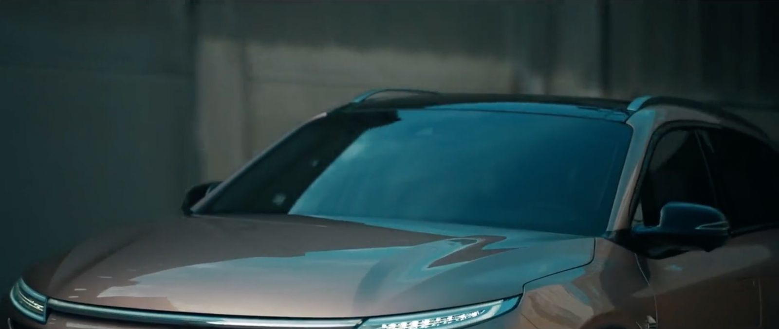 a silver car parked in a garage next to a wall