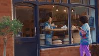 a man and a woman standing in front of a store window