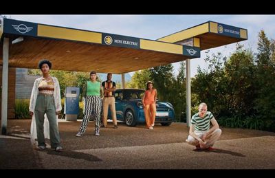 a group of people standing in front of a gas station