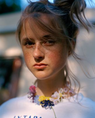 a girl with freckled hair wearing a white shirt