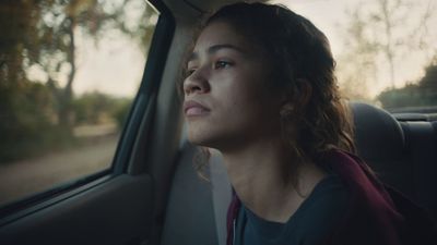 a woman sitting in a car looking out the window