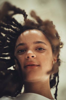 a woman with dreadlocks looking at the camera