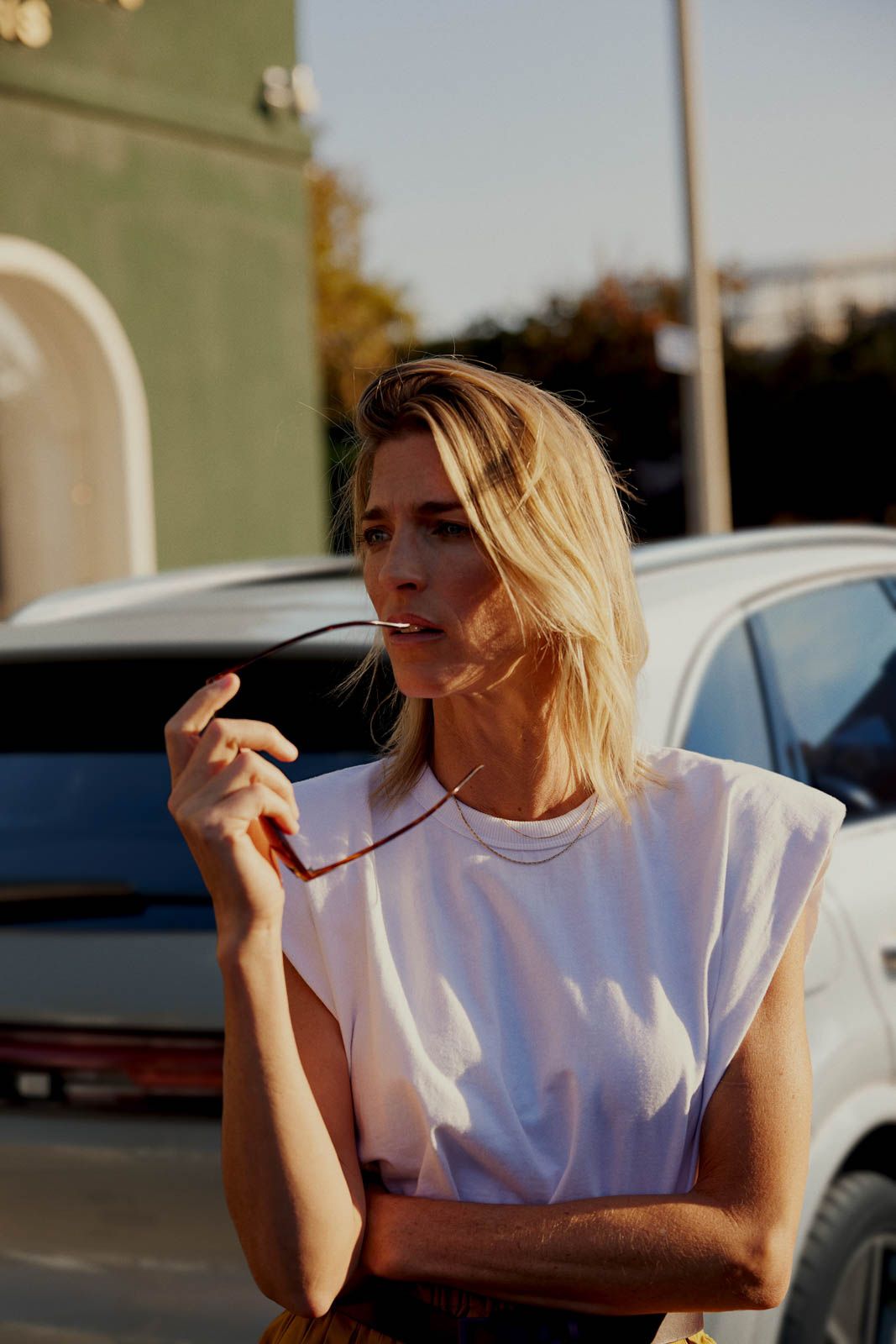 a woman standing in front of a white car