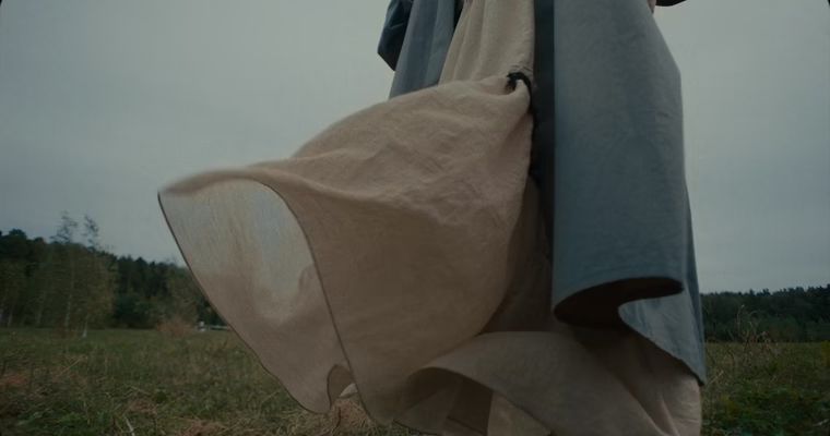 a woman in a dress is holding a bag