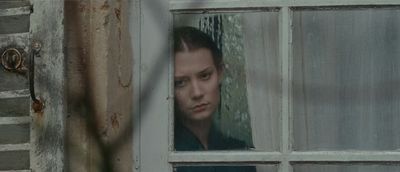 a woman looking out of a window in a house