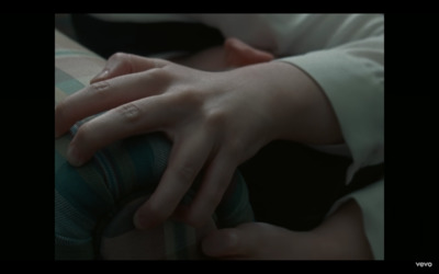 a person with their hands on a pillow