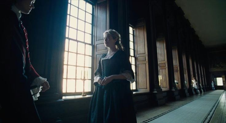 a man and a woman standing in front of a window