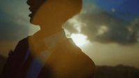 a person standing in front of a cloudy sky