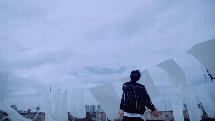 a man standing on top of a roof next to tall buildings