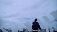 a man standing on top of a roof next to tall buildings