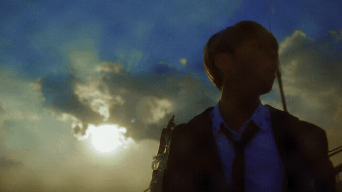 a man standing in front of a cloudy sky