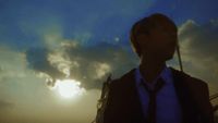 a man standing in front of a cloudy sky