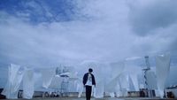 a man standing in front of a large sculpture