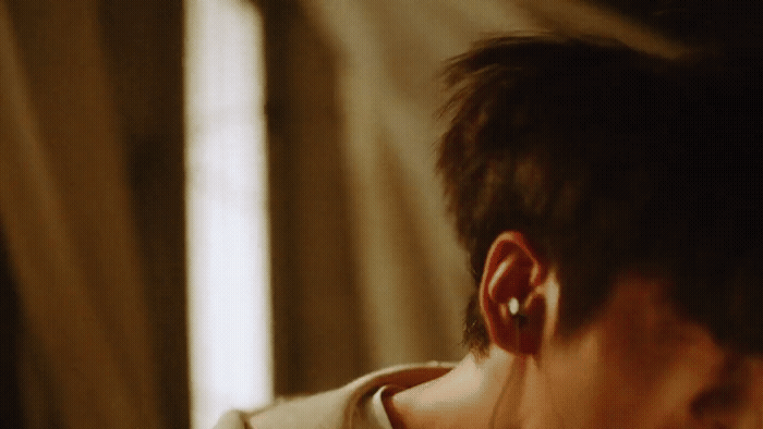a man with ear piercings looking at his cell phone