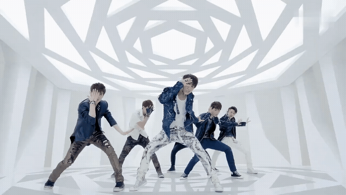 a group of young men dancing in a white room