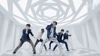 a group of young men dancing in a white room