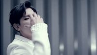 a woman in a white shirt holding her hand to her face