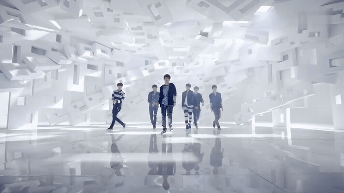a group of people walking through a white room