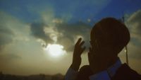 a person standing in front of a cloudy sky