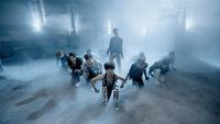 a group of people riding bikes through a foggy room