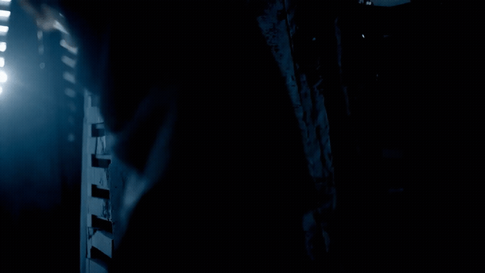 a person standing in a dark room with a light on