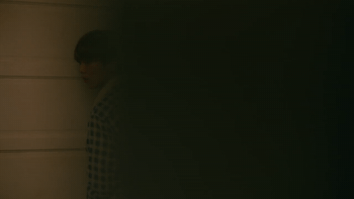 a blurry photo of a person leaning against a wall
