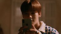 a young boy taking a picture with his cell phone