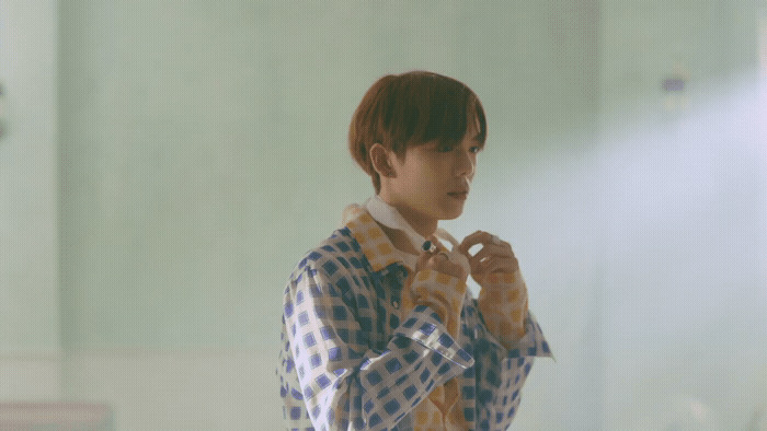 a man standing in front of a mirror brushing his teeth