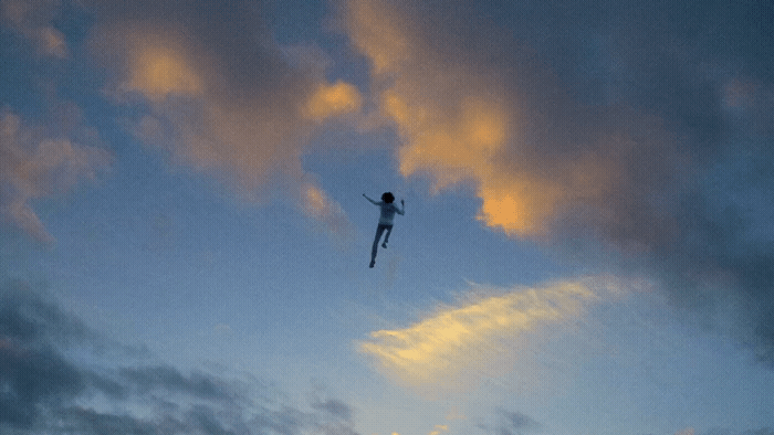 a person flying through the air on top of a kite