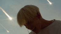 a woman with ear phones on looking at the sky