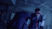 a man in a suit and tie standing next to another man