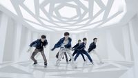a group of young men dancing in a white room
