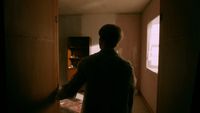 a person standing in a room with a door open