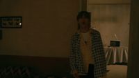 a person standing in a room with a table in the background