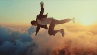 a man flying through the air while wearing a suit
