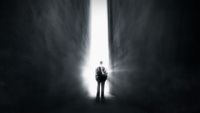 a man standing in the middle of a dark hallway