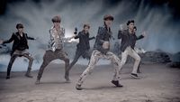 a group of young men dancing in front of a backdrop