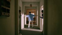 a man in a blue shirt is standing in a hallway