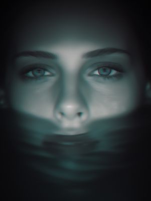 a woman's face with blue eyes in the dark