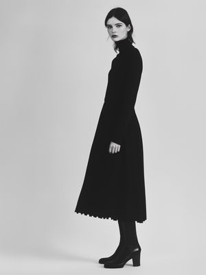 a woman in a black coat and boots