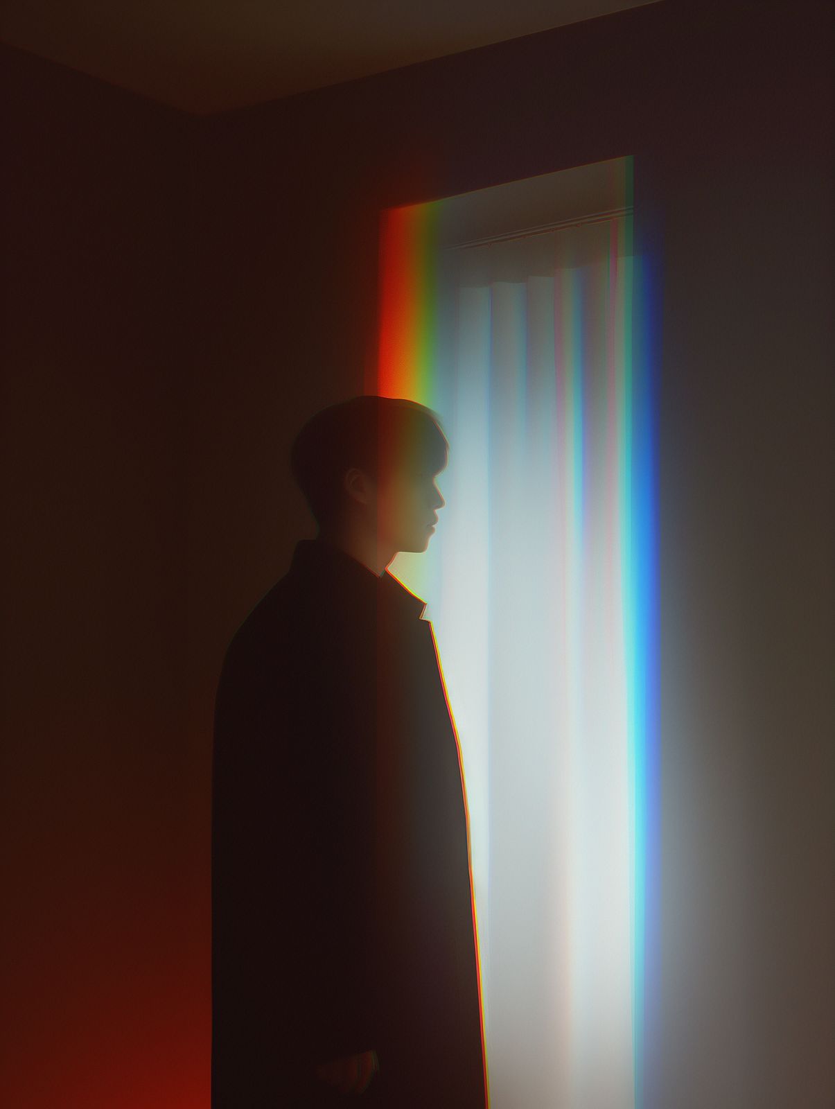 a man standing in front of a rainbow light