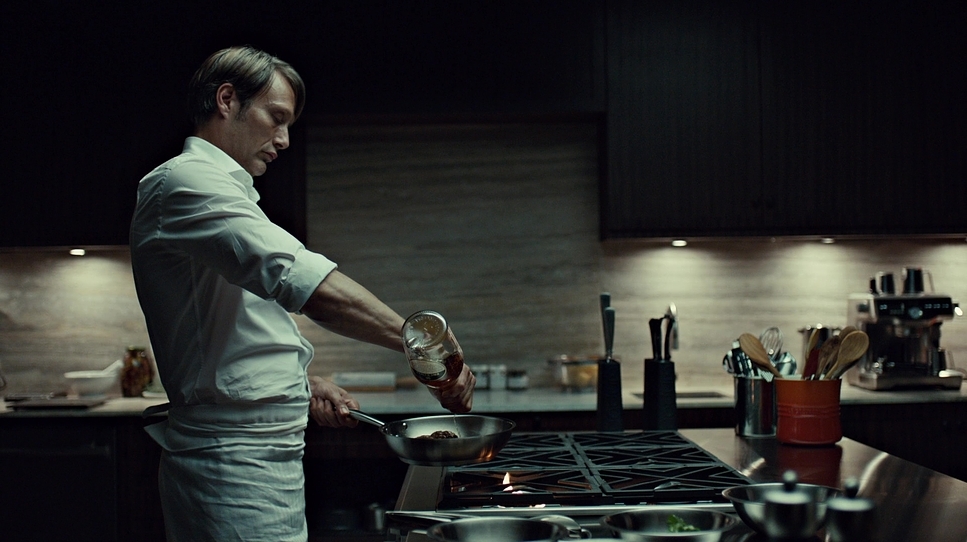 a man in a kitchen cooking food on a stove